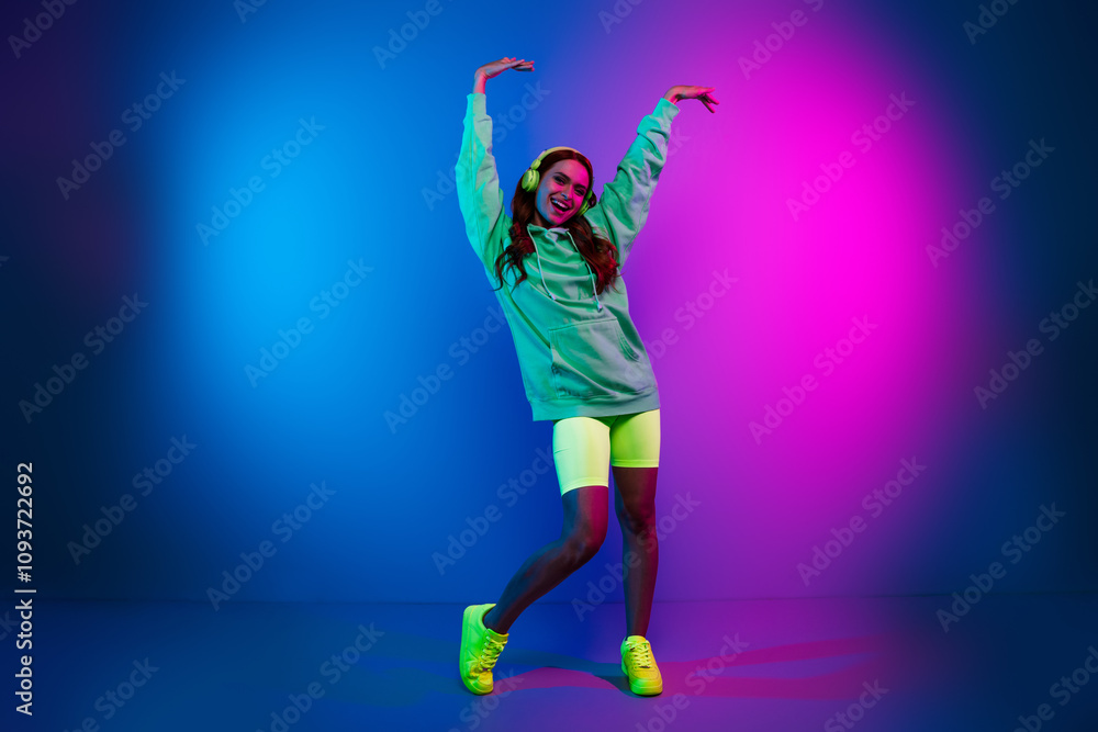 Full length photo of pretty carefree lady dressed sweatshirt earphones having disco fun empty space isolated neon pink color background Full length photo of pretty carefree lady dressed sweatshirt earphones having disco fun empty space isolated neon pink color background
