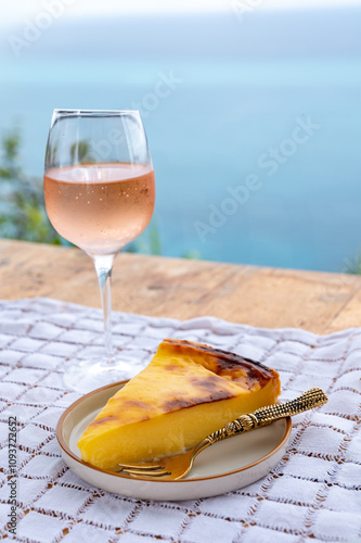 Summer time in Provence, glass of cold rose wine and flan dessert with blue sea view on background, French Riviera near Menton, south of France photo