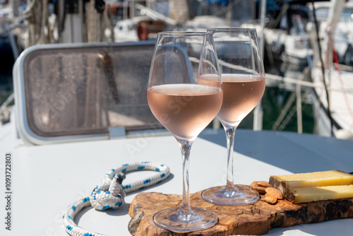 Party with rose wine on yacht boat anchored in port la Rague, Gulf of La Napoule, in Provence, two glasses of cold rose wine, French Riviera near Cannes, south of France