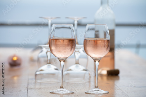 Summer time in Provence, two glasses of cold rose wine with blue sea view on background, French Riviera near Menton, south of France photo