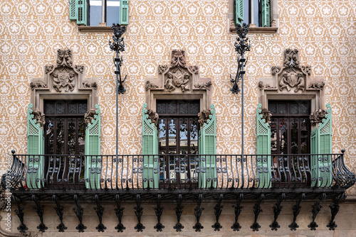 Balcony with cast iron rail, three rectangular windows with open green shutters and moldings. From the Peace Window Series. photo