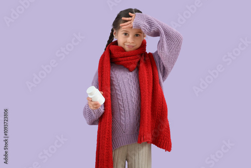 Sick little girl with scarf and pill bottle on lilac background photo