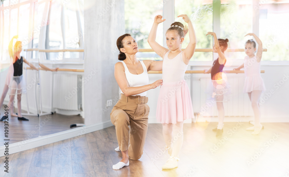 Adult woman teacher helping girl dancer rehearsing choreography in studio Adult woman teacher helping girl dancer rehearsing choreography in studio