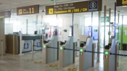 Defocused view of an airport terminal with blurred passport control gates and signs in eu zone creating a travel ambiance