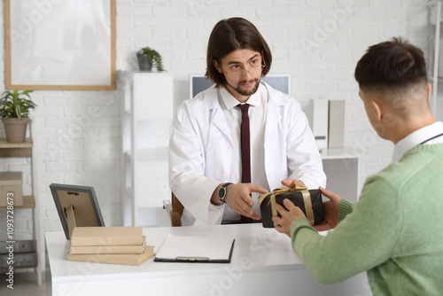 Male doctor taking gift fro...
