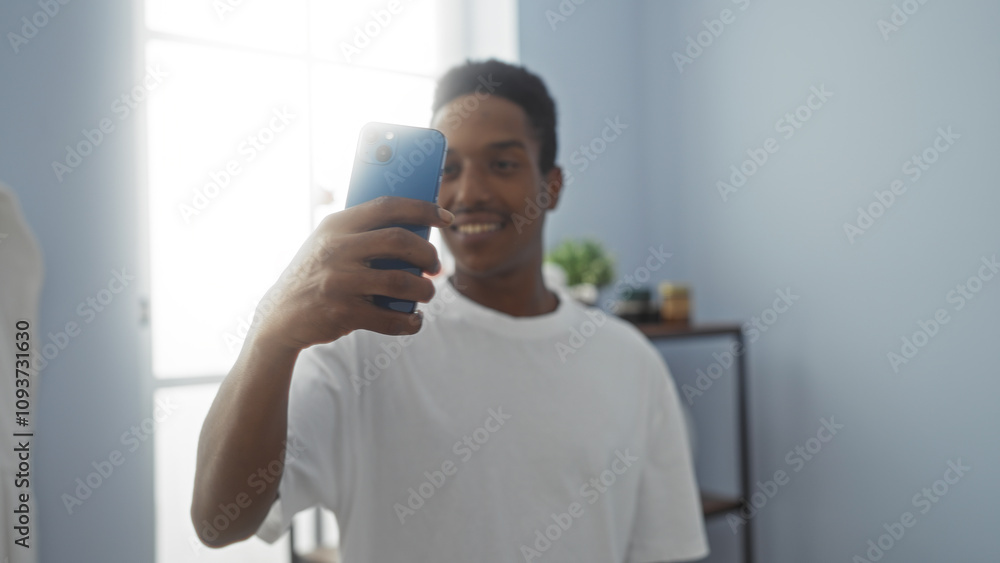 Young man taking selfie in spa room with serene blue walls, showcasing a relaxed, stylish atmosphere ideal for beauty and wellness moments. Young man taking selfie in spa room with serene blue walls, showcasing a relaxed, stylish atmosphere ideal for beauty and wellness moments.