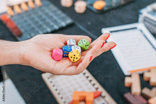 Obraz na płótnie A hand holding colorful dice, symbolizing the concept of tabletop games, statistics, and probability. w salonie