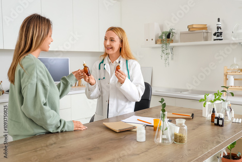 Cuadro en lienzo Female homeopathic doctor giving dropper bottles to patient in office
