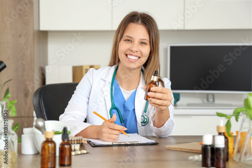 Female homeopathic doctor with dropper bottle working at table in office