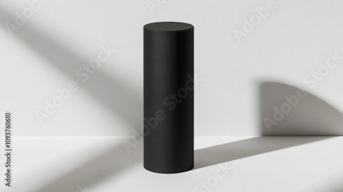 A tall, cylindrical box with a matte black finish, standing upright on a clean white surface