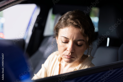 Woman doing test drive, examining car before making investment, exploring compartments. Client driving vehicle, pushing buttons to make sure everything is in good working order photo