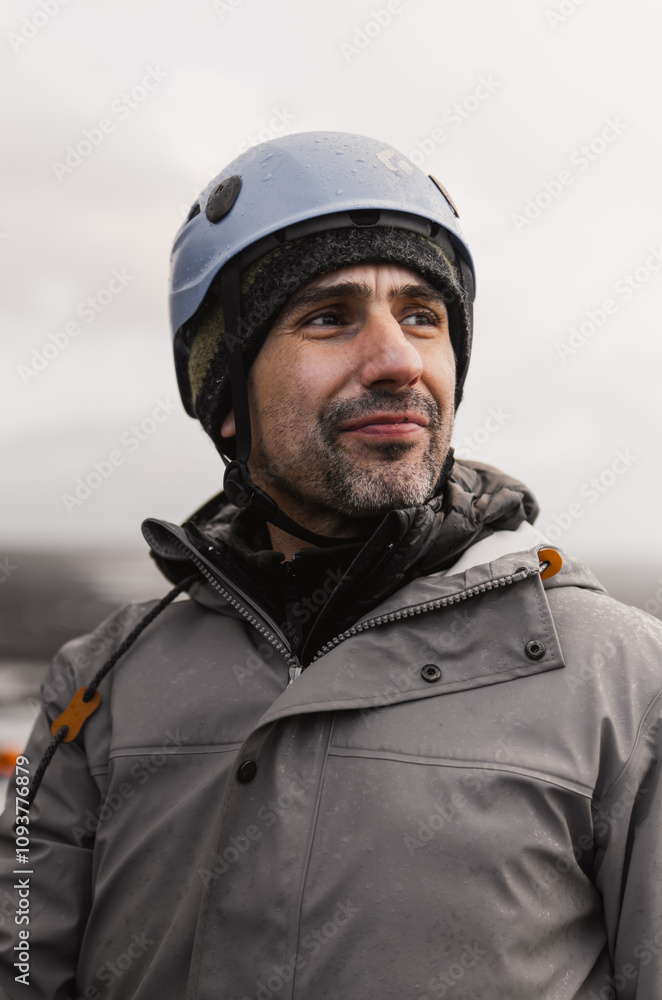 Geologist wearing a helmet and smiling during a rainy day in a natural environment Geologist wearing a helmet and smiling during a rainy day in a natural environment
