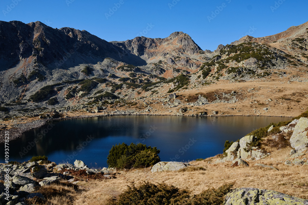 Serene mountain lake nestled amidst rugged peaks under a clear blue sky. Ideal for travel, nature, and landscape projects. Serene mountain lake nestled amidst rugged peaks under a clear blue sky. Ideal for travel, nature, and landscape projects.