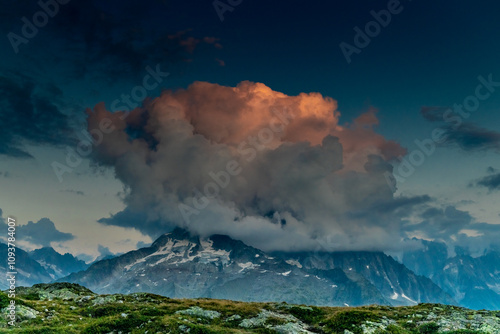 Petit Dru granite mountain wall and summit in Chamonix valley, french Alps. Prominent mountain peak in the Alps, stunning landscape view of the rocky peak covered with clouds, snow and ice