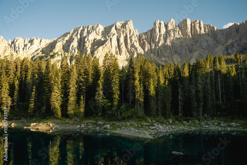 A beautiful lake is surrounded by tall trees and a majestic mountain