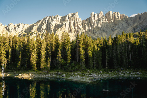 A beautiful lake is surrounded by tall trees and a majestic mountain