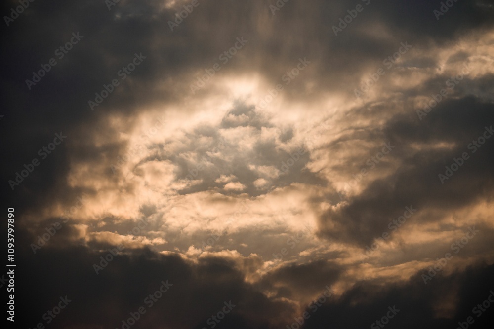 Fototapeta premium Golden sunlight through stormy clouds