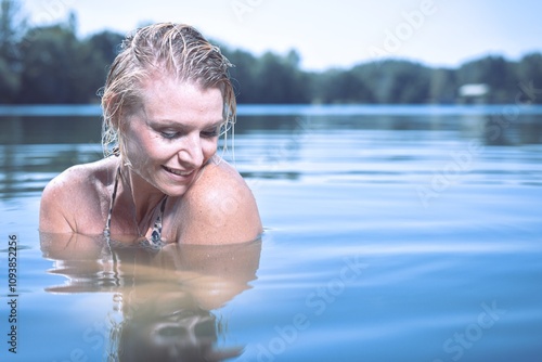 Pretty lady in summer lake posing for portrait in daytime photo