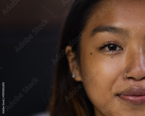 Close-up of asian female teenager smiling with nose ring and earrings, copy space, at home photo