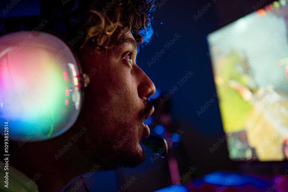 Photo of cute young guy excited amazed play gamer computer purple blue neon light indoors late night Photo of cute young guy excited amazed play gamer computer purple blue neon light indoors late night