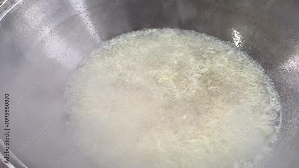 The onion is being sautéed in oil in a big pot, the initial stage of preparing pilaf. The onion is being sautéed in oil in a big pot, the initial stage of preparing pilaf.