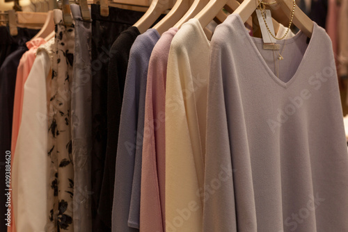 Women's jumpers on hangers in the store. Different colors and styles. Style and fashion. photo