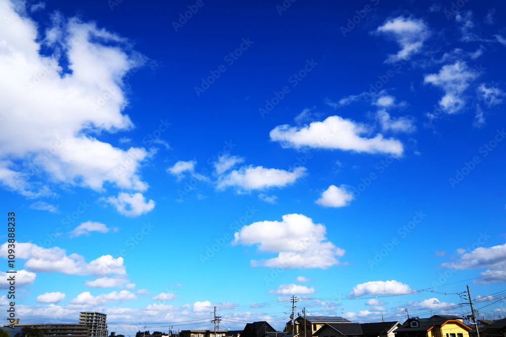 Fototapeta premium 青空に浮かぶ白い雲と住宅街