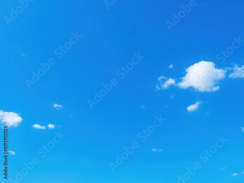 Small blue dots scattered across a vast expanse of blue sky with some scattered white clouds, abstract, white clouds,