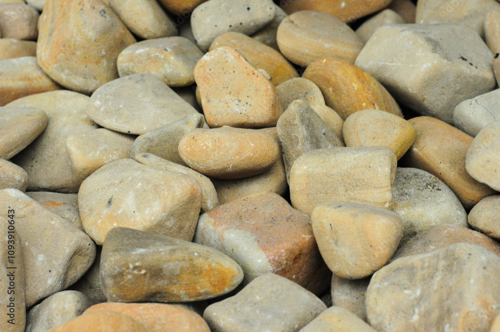 Close-up of smooth river stones in earthy tones for landscaping or decor use Close-up of smooth river stones in earthy tones for landscaping or decor use