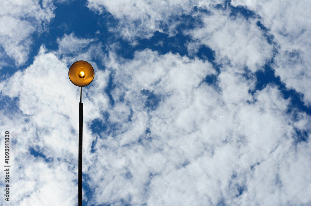 Streetlamp with fluffy clouds and deep blue sky backdrop, capturing serenity Streetlamp with fluffy clouds and deep blue sky backdrop, capturing serenity