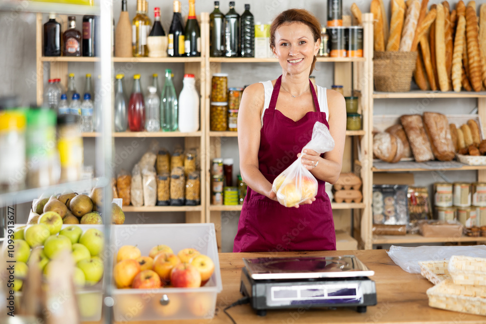 Female selling food products weighs ripe apples on scales Female selling food products weighs ripe apples on scales