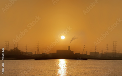 夕暮れ時の工場地帯を照らす夕日の明かり