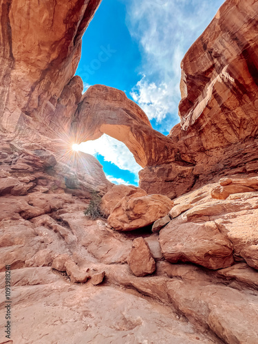 double arch sun flare arches national park photo