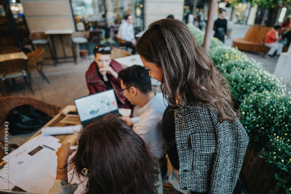 A diverse group of business people discuss ideas and analyze concepts while working together at an outdoor cafe. The scene captures teamwork and collaboration in a casual setting. A diverse group of business people discuss ideas and analyze concepts while working together at an outdoor cafe. The scene captures teamwork and collaboration in a casual setting.