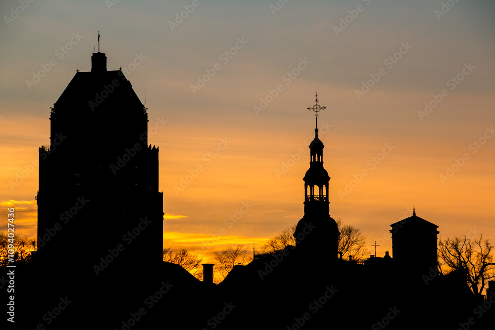 Fototapeta premium Silhouette of the The Notre-Dame de Québec Basilica-Cathedral church steeple and Édifice Price building among the skyline of Quebec City, Quebec, Canada.