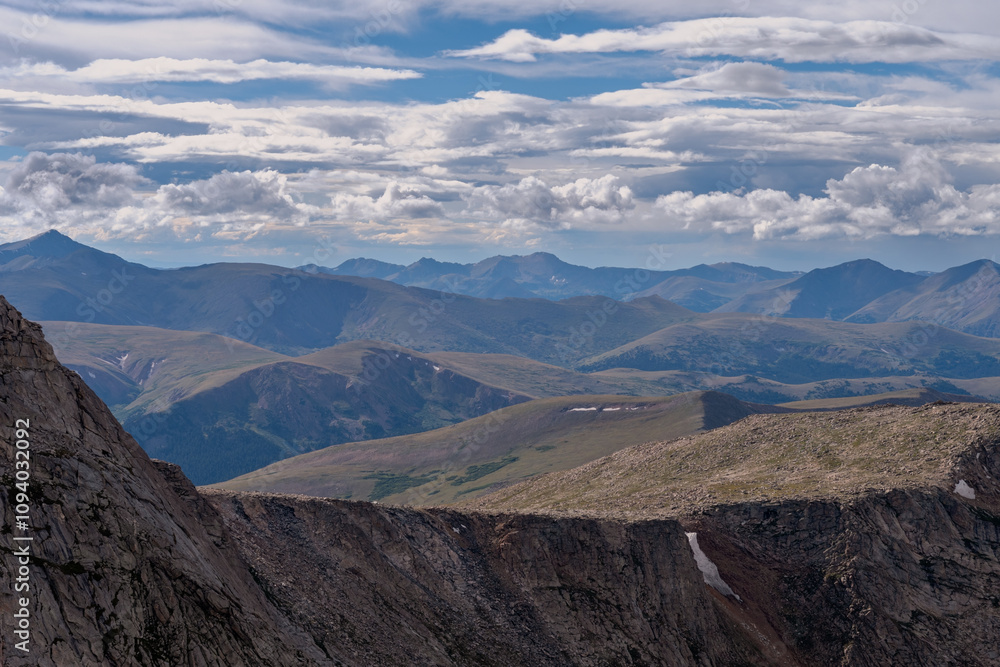 Expansive mountain landscape under a cloudy sky showcases rugged terrain and rolling hills in a remote wilderness area during daylight hours Expansive mountain landscape under a cloudy sky showcases rugged terrain and rolling hills in a remote wilderness area during daylight hours