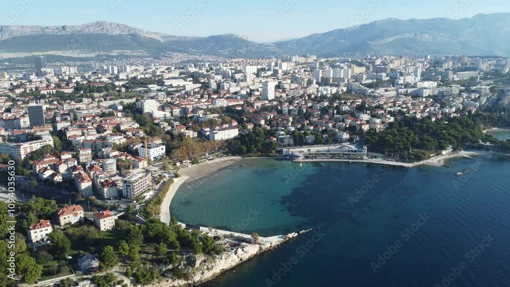 Vídeo em 4K capturado por drone mostrando a praia Bacvice em Split, Croácia, em um dia de sol, destacando suas águas cristalinas, areia dourada e o ambiente vibrante à beira-mar Vídeo em 4K capturado por drone mostrando a praia Bacvice em Split, Croácia, em um dia de sol, destacando suas águas cristalinas, areia dourada e o ambiente vibrante à beira-mar