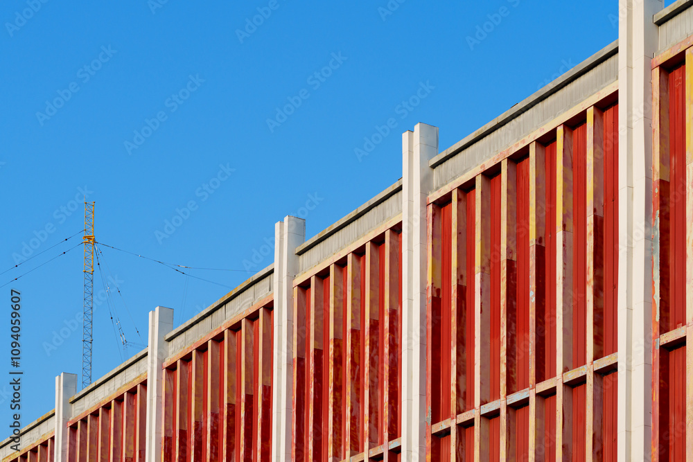 Rhythm of architecture: frame exterior facade of a building in red color under blue sky Rhythm of architecture: frame exterior facade of a building in red color under blue sky
