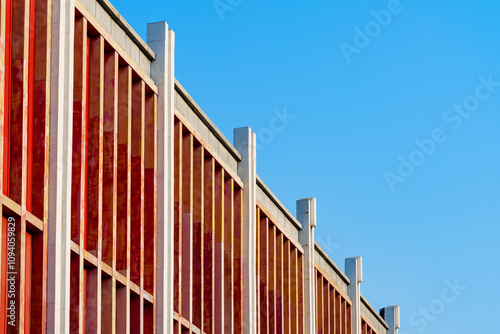 Rhythm of architecture: frame exterior facade of a building in red color under blue sky