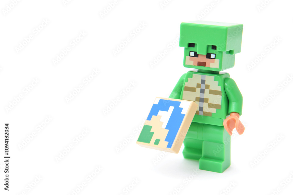 Naklejka premium Lego minifigure of popular game Minecraft with pixel map isolated on white. Editorial illustrative image of popular plastic toys.