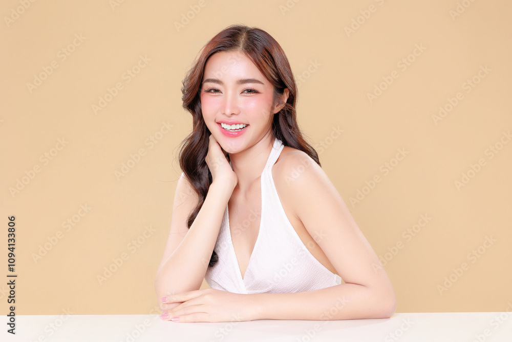 Pretty Asian beauty woman curly long hair with Korean makeup glowing face and healthy facial skin portrait smile on isolated beige background. Cosmetology ,Plastic surgery. Pretty Asian beauty woman curly long hair with Korean makeup glowing face and healthy facial skin portrait smile on isolated beige background. Cosmetology ,Plastic surgery.