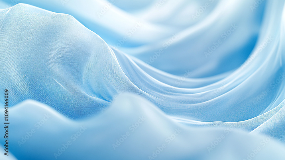 Fototapeta premium Soft blue fabric drapes creating gentle waves and folds for a serene visual