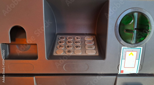 keypad number and receipt and debit card ejection slot on automated teller machine  photo