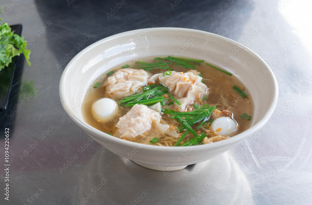 China noodle with pork wonton soup or pork dumplings soup with vegetable. Egg noodles with pork wonton soup or pork dumplings soup and vegetable. China noodle with pork wonton soup or pork dumplings soup with vegetable. Egg noodles with pork wonton soup or pork dumplings soup and vegetable.