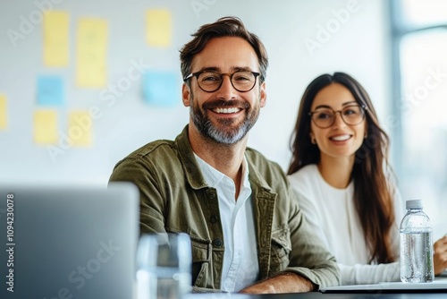 Professionals in Modern Office Engaged in Discussion with Laptop and Notepad