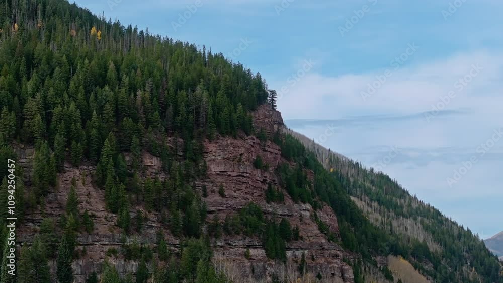 Majestic cliffs and lush green trees on a bright day, showing Vail's rugged natural beauty, aerial orbit establishing Majestic cliffs and lush green trees on a bright day, showing Vail's rugged natural beauty, aerial orbit establishing