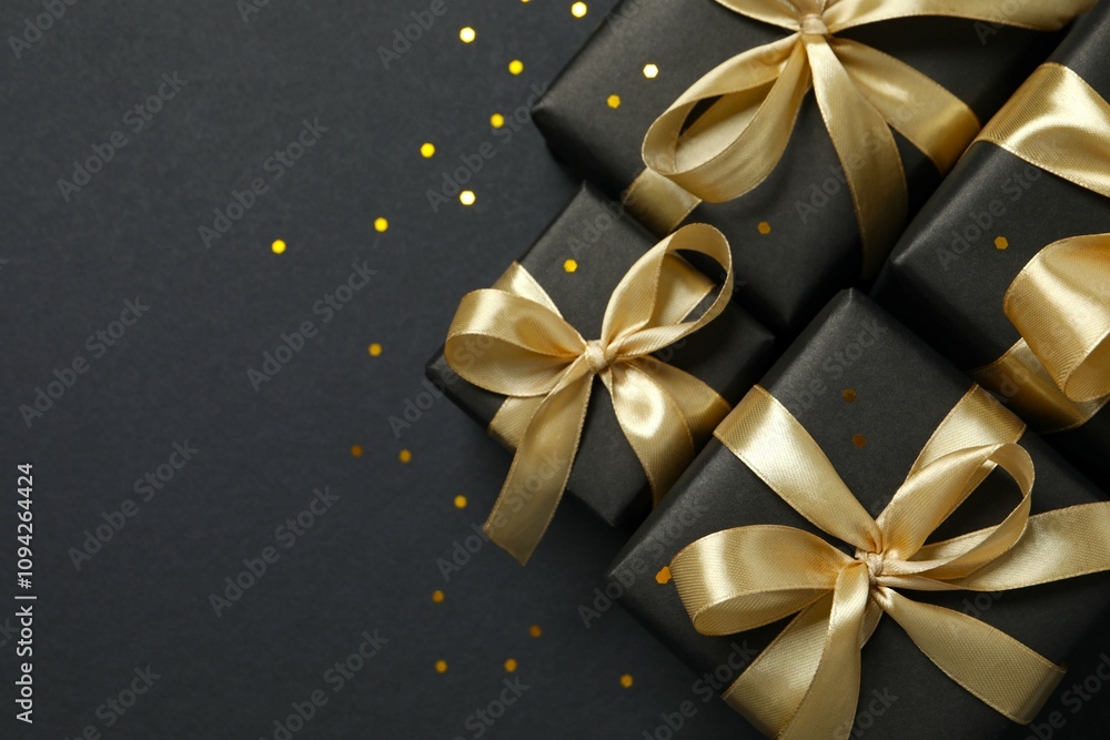 Beautiful gift boxes tied with bows on black background Beautiful gift boxes tied with bows on black background