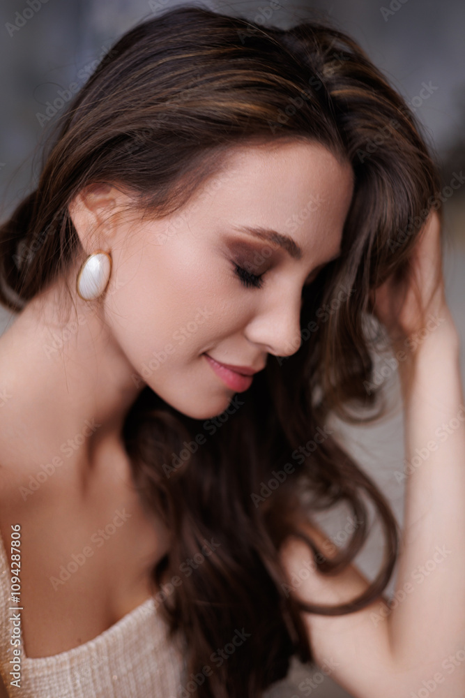 A beautiful girl in a short elegant beige gold dress stands on the sand. Portrait of a beautiful woman on a gray background. Bright make-up and long hair. Gorgeous brunette woman portrait A beautiful girl in a short elegant beige gold dress stands on the sand. Portrait of a beautiful woman on a gray background. Bright make-up and long hair. Gorgeous brunette woman portrait