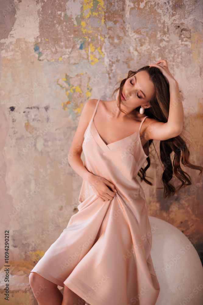 A beautiful slender tall brunette in a silk beige dress. A magnificent portrait of a gorgeous girl with long hair down, stand on sand A beautiful slender tall brunette in a silk beige dress. A magnificent portrait of a gorgeous girl with long hair down, stand on sand