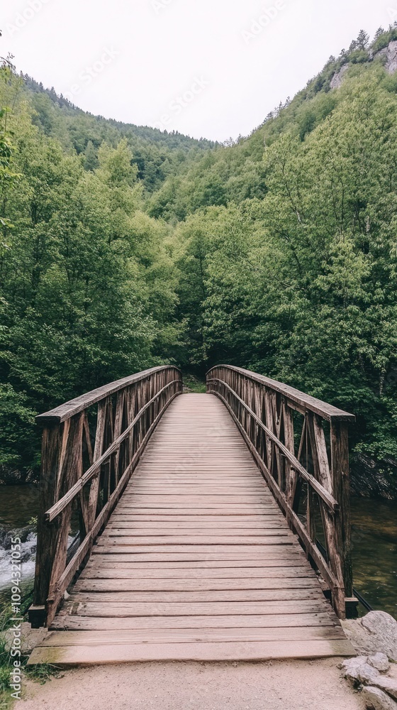 A wooden bridge spans a serene landscape, surrounded by lush green trees and hills. A wooden bridge spans a serene landscape, surrounded by lush green trees and hills.